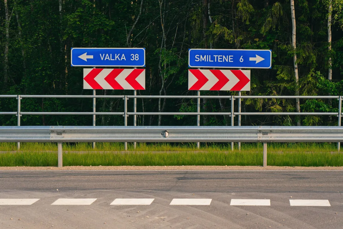 Virziena zīmes „Valka 38” un „Smiltene 6” aiz ceļa barjeras